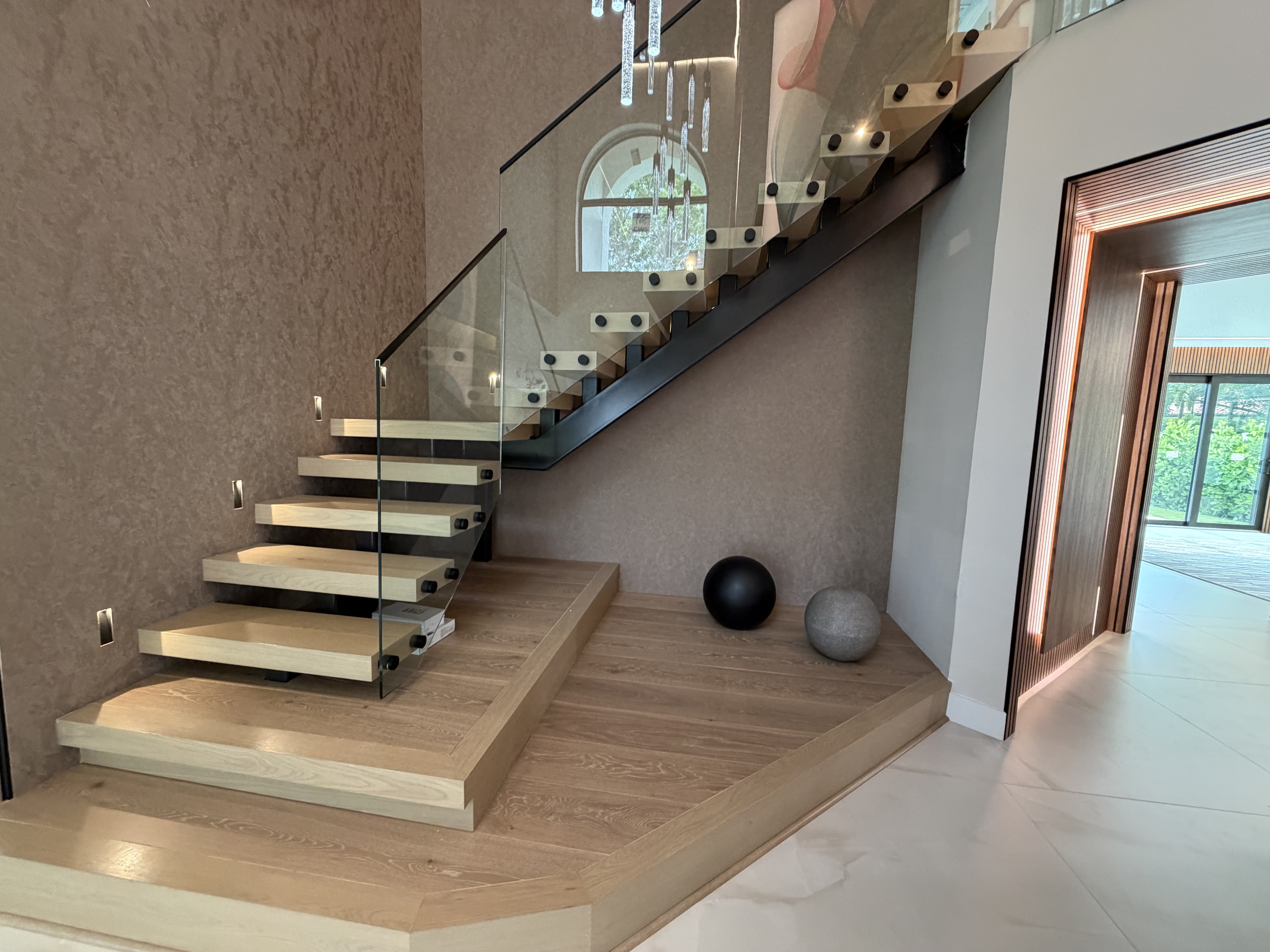 Custom floating staircase with glass railing and wood platform